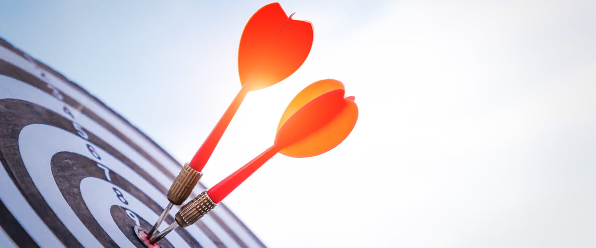 Darts hitting a bullseye symbolising focus, intention and self-mastery.”